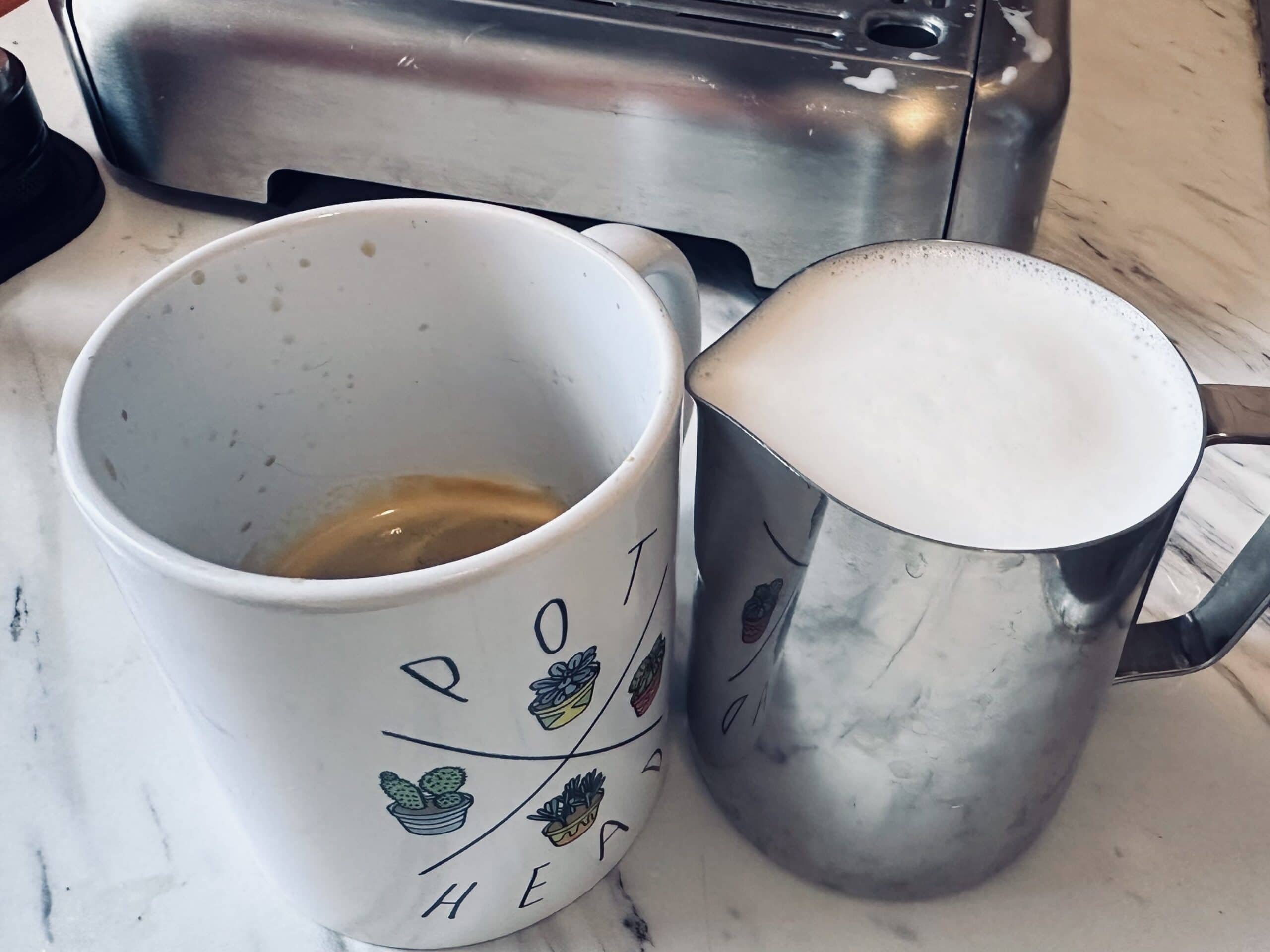 a cup of espresso with a cup of brewed milk