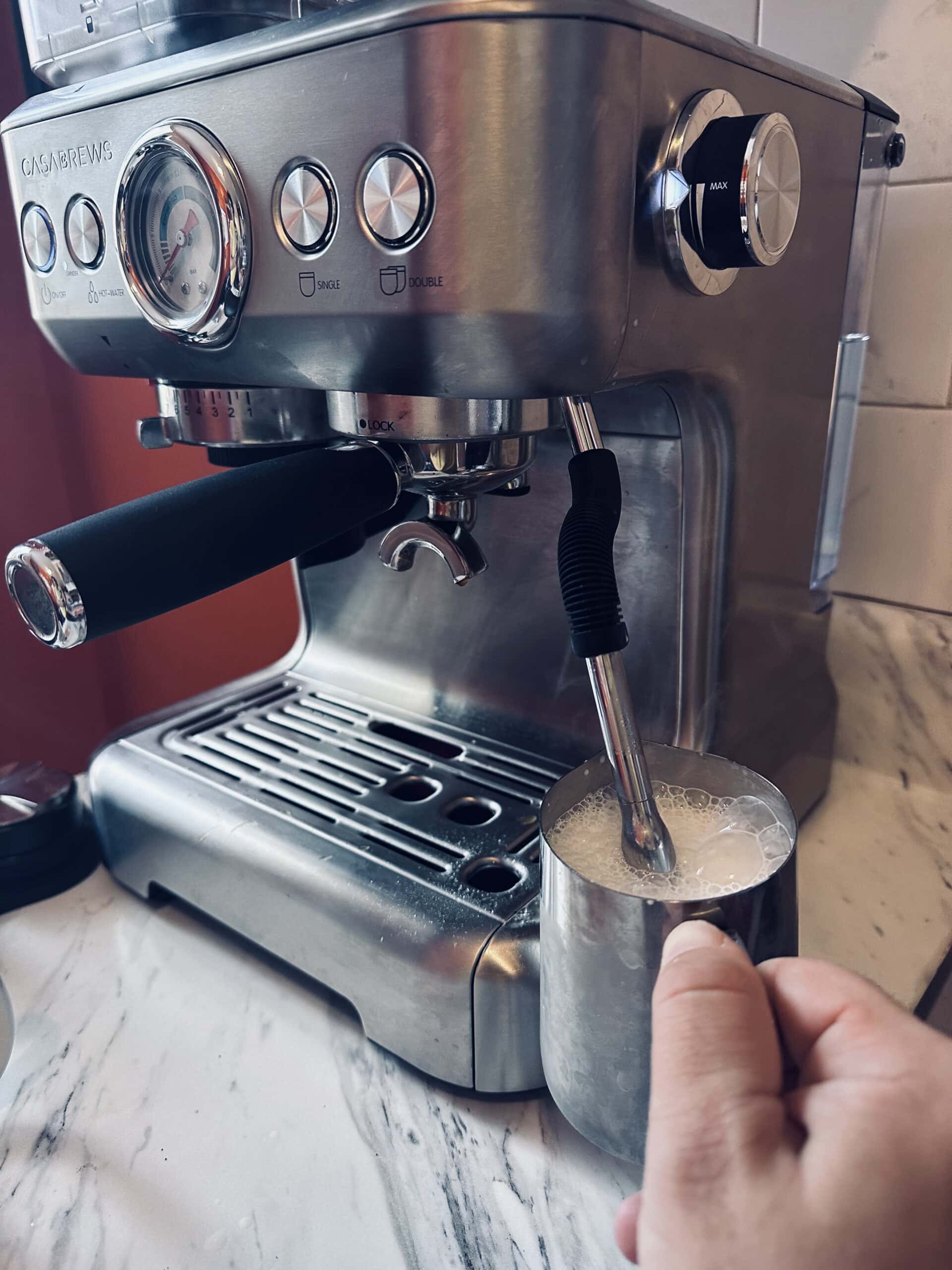 Casabrews Espresso Machine brews milk in a metal mug