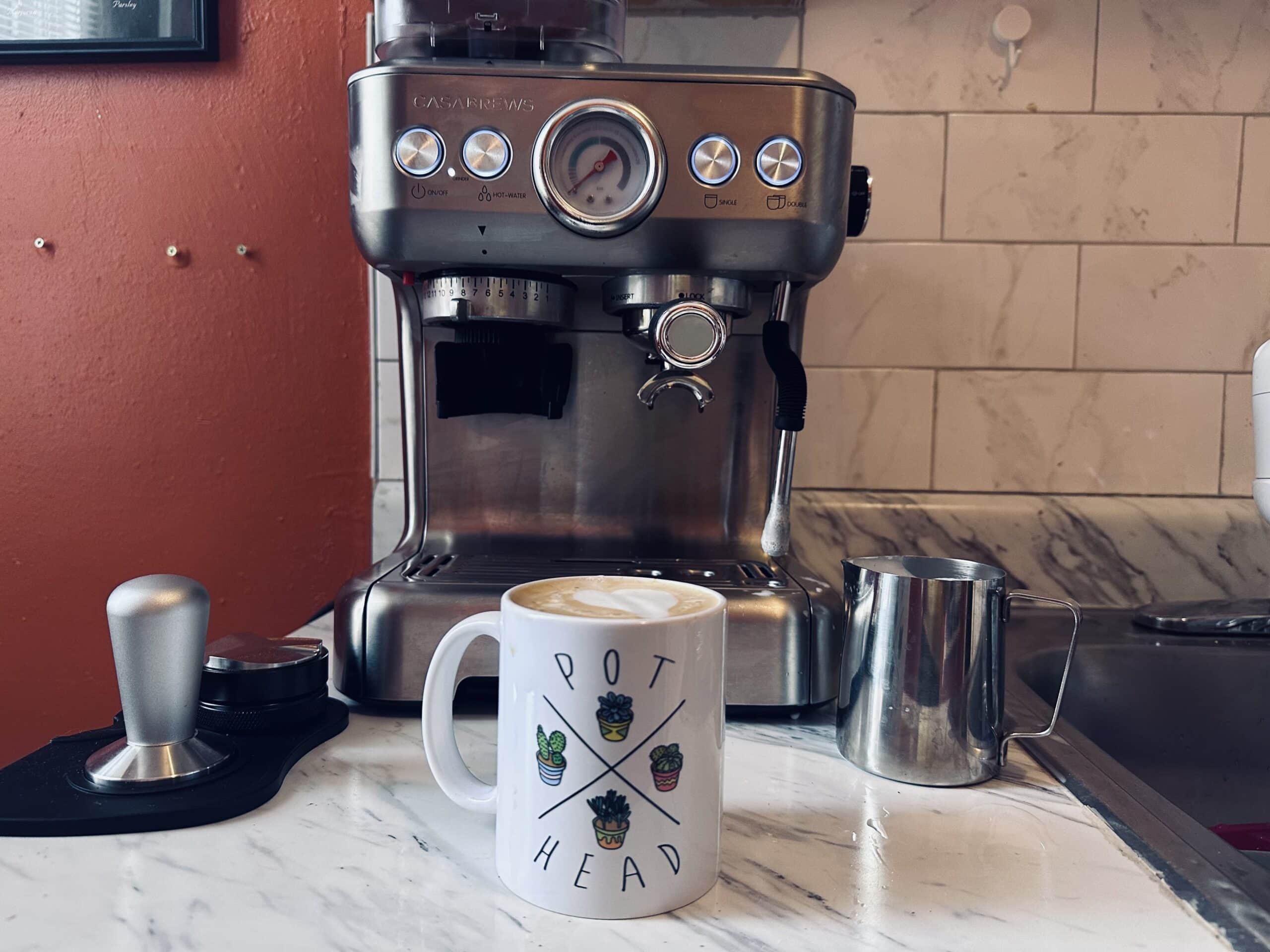 Casabrews Espresso Machine next to a brewed cup of coffee