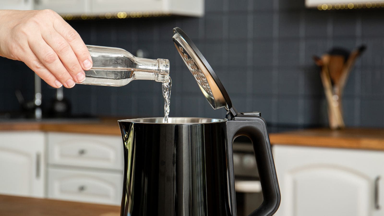 woman pouring Citric Acid into electric kettle 