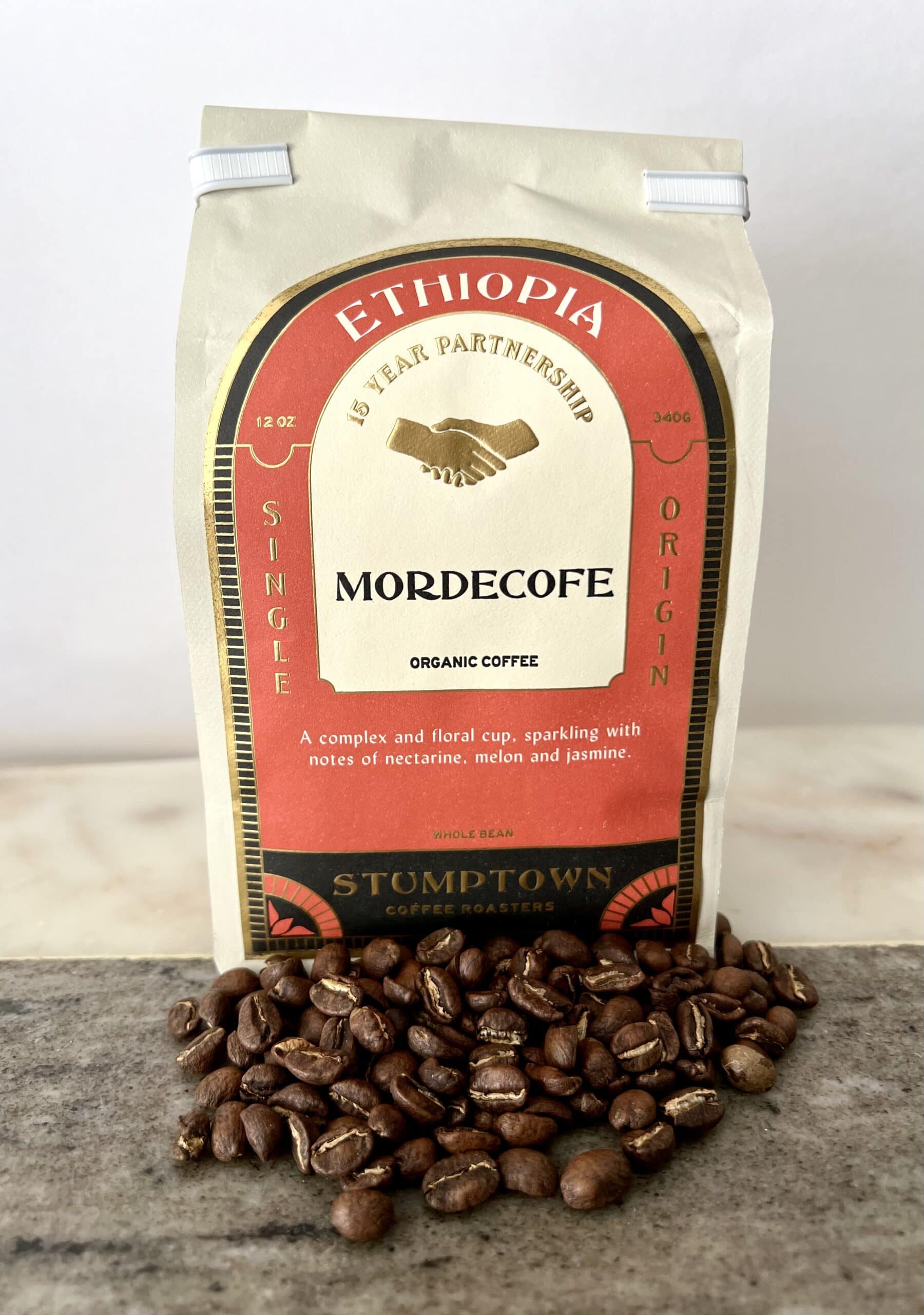 Ethiopia Mordecofe coffee packaging stands on coffee beans