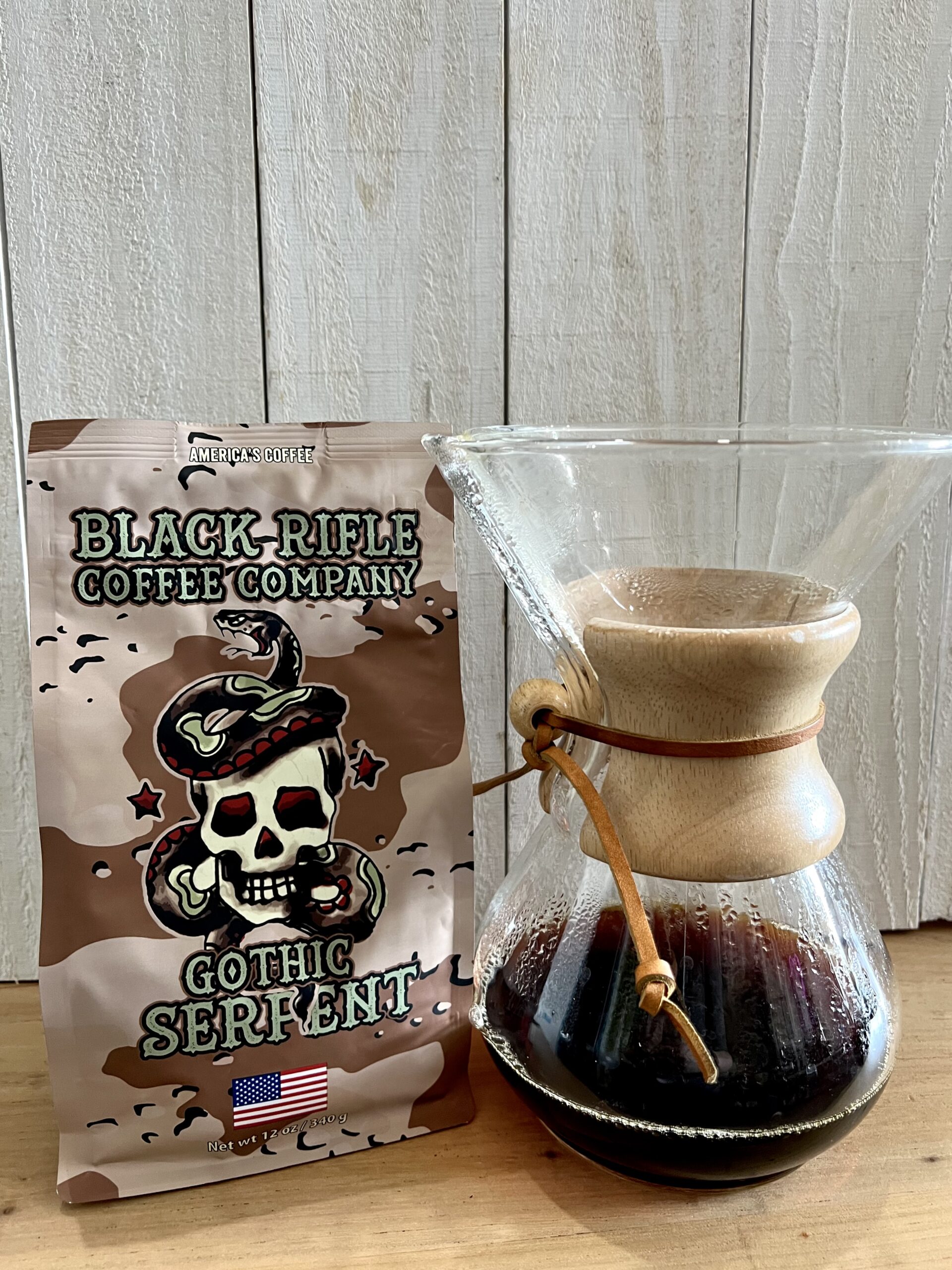 Gothic Serpent Black Rifle Coffee pack next to brewed coffee in Chemex