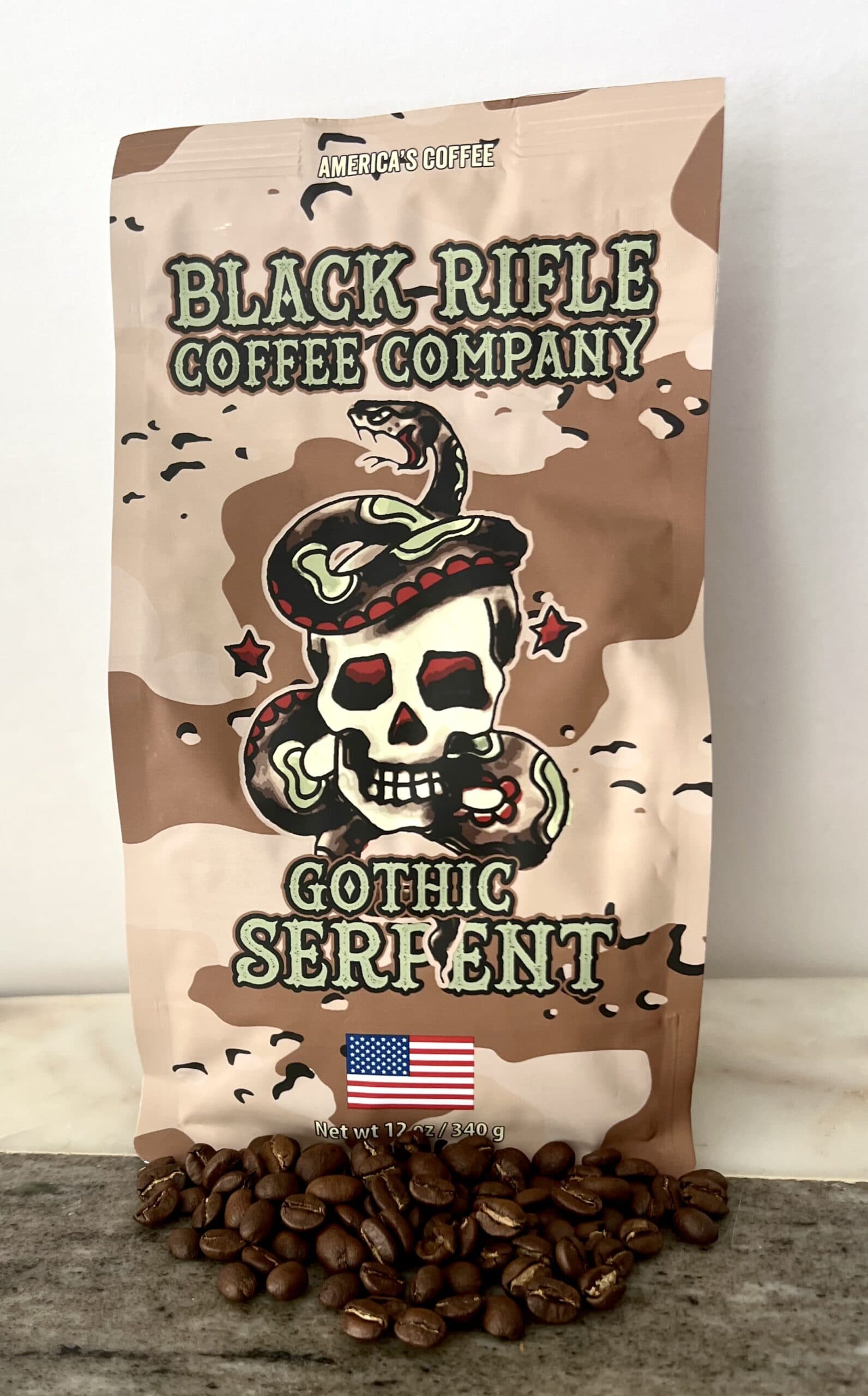 Gothic Serpent Black Rifle Coffee pack next to scattered coffee beans