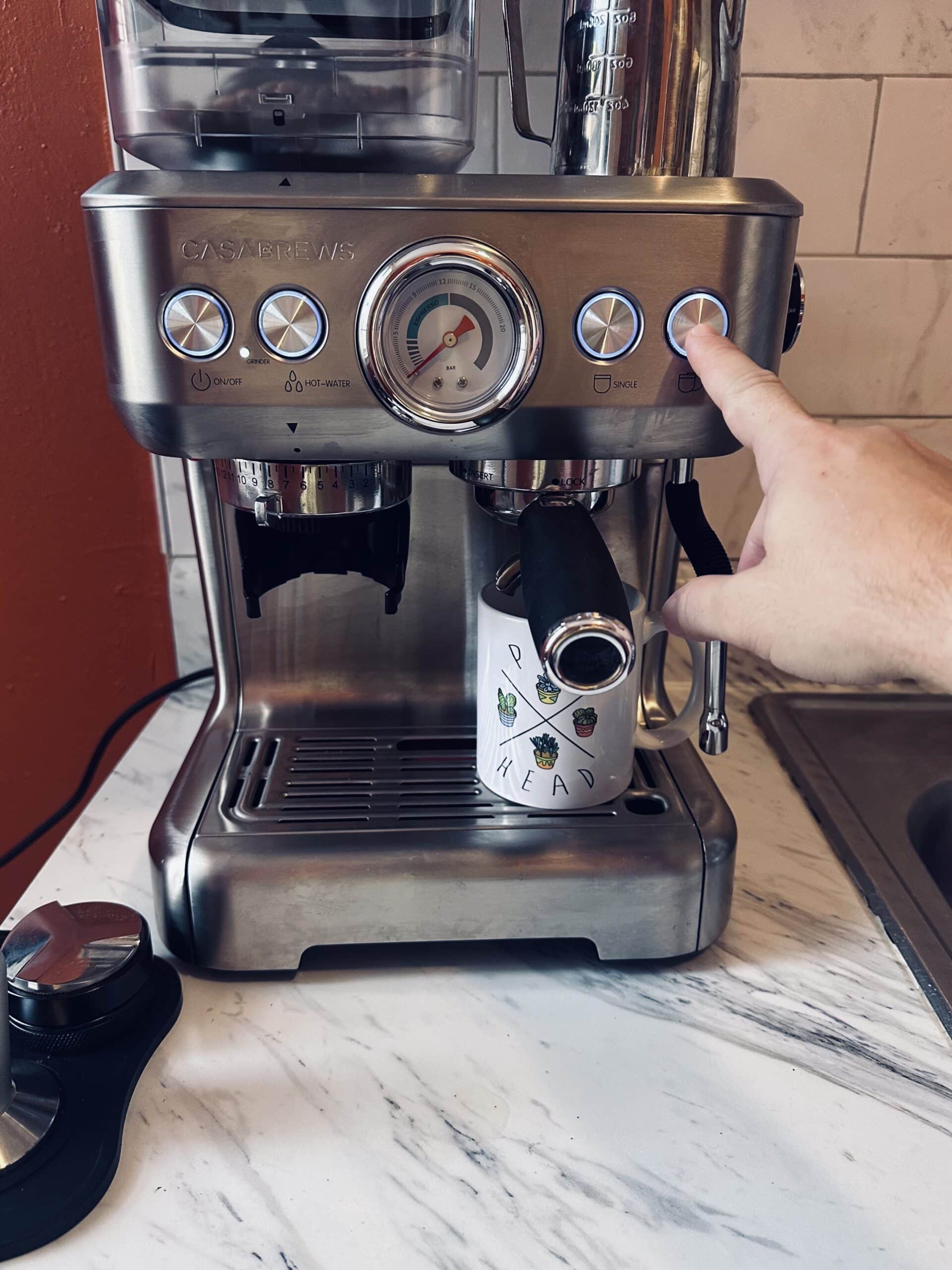 hand presses the button of Casabrews Espresso Machine