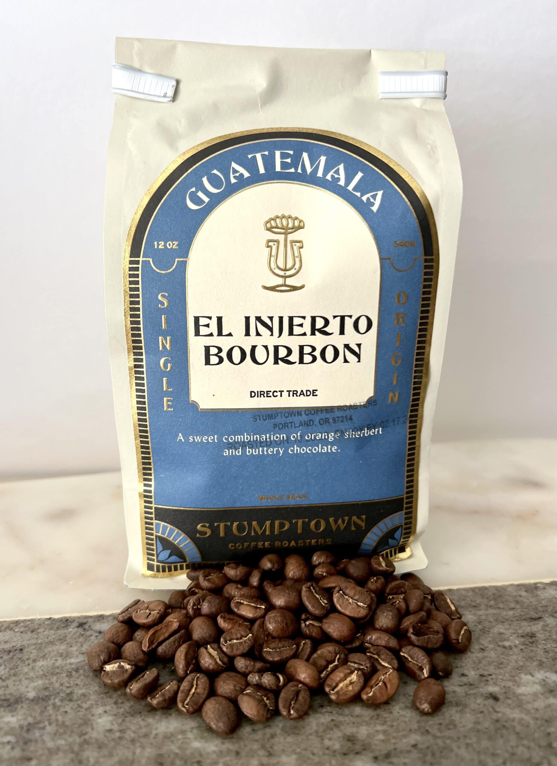 packaging of Guatemala El Injerto Bourbon coffee stands on coffee beans
