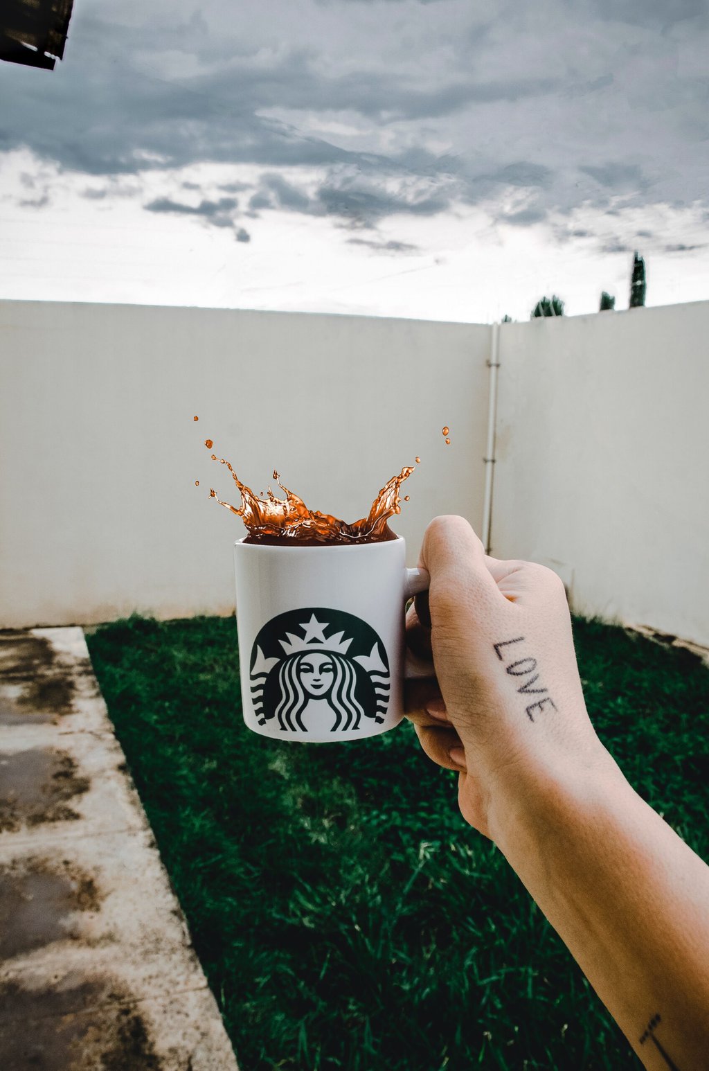 person holding Starbucks cup with coffee drink